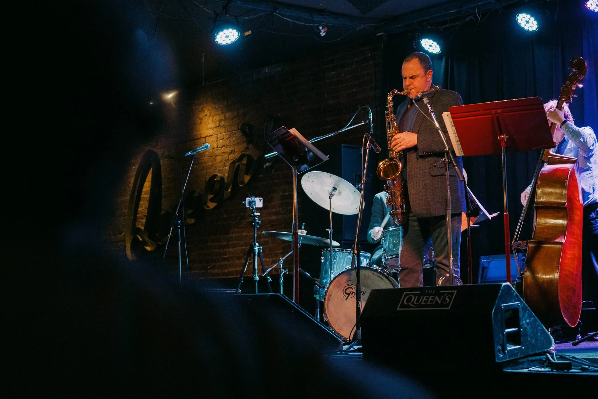 A saxophonist performs with his band at The Queen's