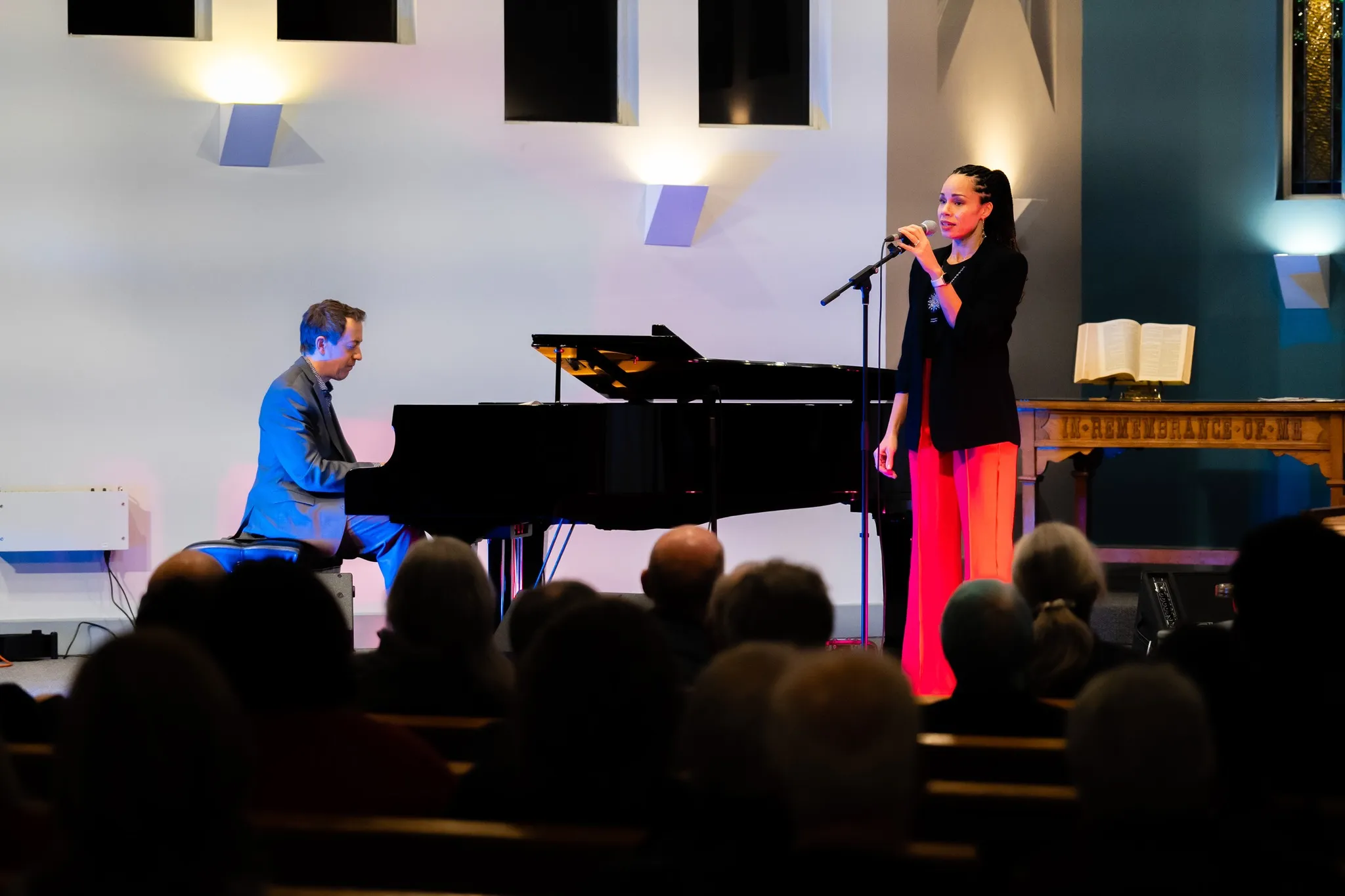 A vocalist and pianist performing for a seated audience