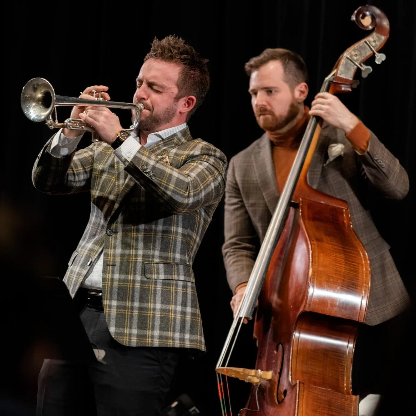 A trumpeter and bassist performing on stage